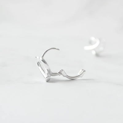 クロスラインの入ったハートモチーフのハギーピアス（シルバー925）。金属アレルギー対応。