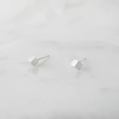 シルバー925のキューブ型スタッドピアス。ミニマルで重ね着けにも最適なデザイン。金属アレルギー対応。925 sterling silver cube stud earrings with minimalist design, perfect for layering. Hypoallergenic finish.