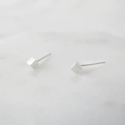 シルバー925のキューブ型スタッドピアス。ミニマルで重ね着けにも最適なデザイン。金属アレルギー対応。925 sterling silver cube stud earrings with minimalist design, perfect for layering. Hypoallergenic finish.