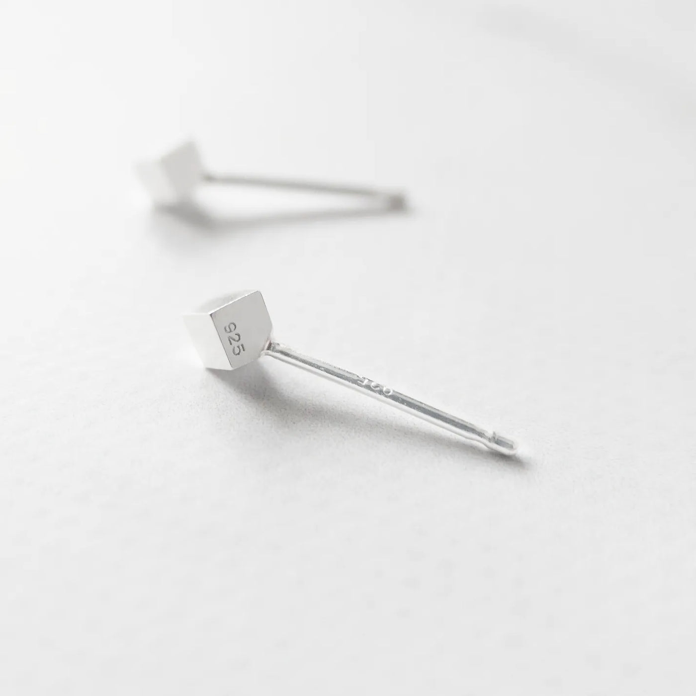 シルバー925のキューブ型スタッドピアス。ミニマルで重ね着けにも最適なデザイン。金属アレルギー対応。925 sterling silver cube stud earrings with minimalist design, perfect for layering. Hypoallergenic finish.