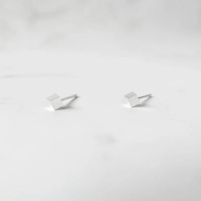 シルバー925のキューブ型スタッドピアス。ミニマルで重ね着けにも最適なデザイン。金属アレルギー対応。925 sterling silver cube stud earrings with minimalist design, perfect for layering. Hypoallergenic finish.