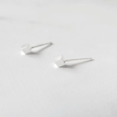 シルバー925のキューブ型スタッドピアス。ミニマルで重ね着けにも最適なデザイン。金属アレルギー対応。925 sterling silver cube stud earrings with minimalist design, perfect for layering. Hypoallergenic finish.