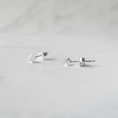 シルバー925のキューブ型スタッドピアス。ミニマルで重ね着けにも最適なデザイン。金属アレルギー対応。925 sterling silver cube stud earrings with minimalist design, perfect for layering. Hypoallergenic finish.