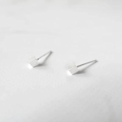 シルバー925のキューブ型スタッドピアス。ミニマルで重ね着けにも最適なデザイン。金属アレルギー対応。925 sterling silver cube stud earrings with minimalist design, perfect for layering. Hypoallergenic finish.
