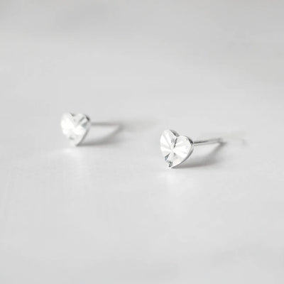 繊細なカットを施したハートモチーフのシルバー925スタッドピアス。光の反射で上品に輝くミニマルデザイン。金属アレルギー対応。
Delicately faceted heart-shaped 925 sterling silver stud earrings with a refined shine. Minimalist design, hypoallergenic.