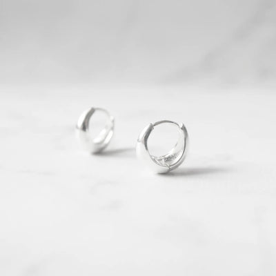 無鍍層のシルバー925を使用したクラシックハギーピアス。自然な艶感とミニマルなデザインが魅力。Classic huggie earrings in unplated 925 sterling silver with natural shine and minimalist design.