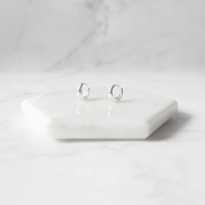 無鍍層のシルバー925を使用したクラシックハギーピアス。自然な艶感とミニマルなデザインが魅力。Classic huggie earrings in unplated 925 sterling silver with natural shine and minimalist design.