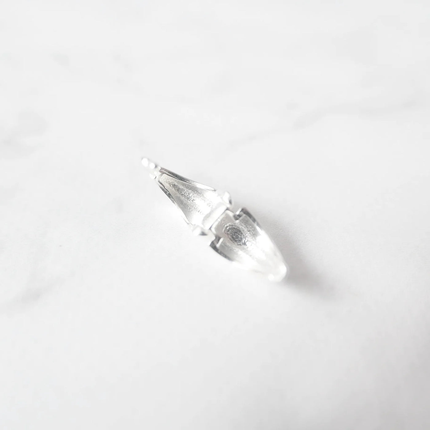 無鍍層のシルバー925を使用したクラシックハギーピアス。自然な艶感とミニマルなデザインが魅力。Classic huggie earrings in unplated 925 sterling silver with natural shine and minimalist design.