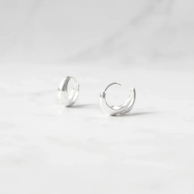 無鍍層のシルバー925を使用したクラシックハギーピアス。自然な艶感とミニマルなデザインが魅力。Classic huggie earrings in unplated 925 sterling silver with natural shine and minimalist design.