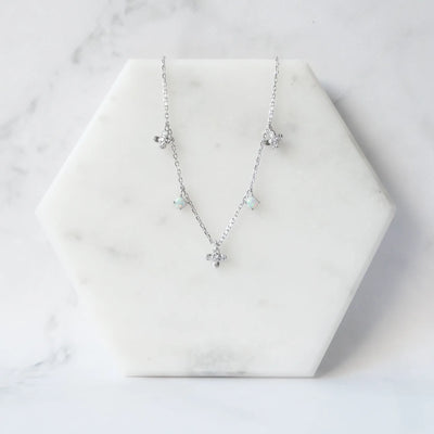 オパールとクリスタルチャームが並んだ、繊細で軽やかなシルバーネックレス。ロジウムプレーティング、金属アレルギー対応。