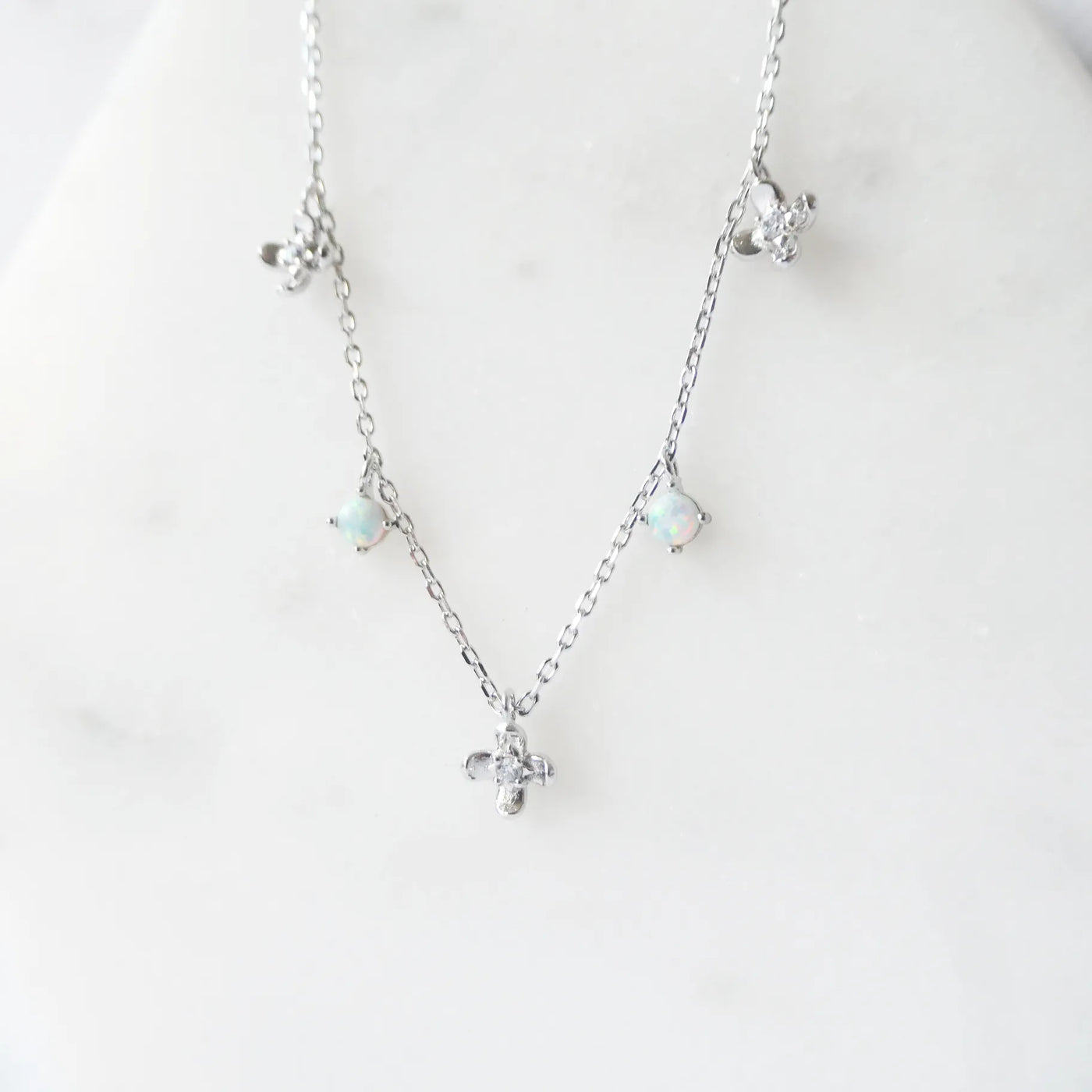 オパールとクリスタルチャームが並んだ、繊細で軽やかなシルバーネックレス。ロジウムプレーティング、金属アレルギー対応。