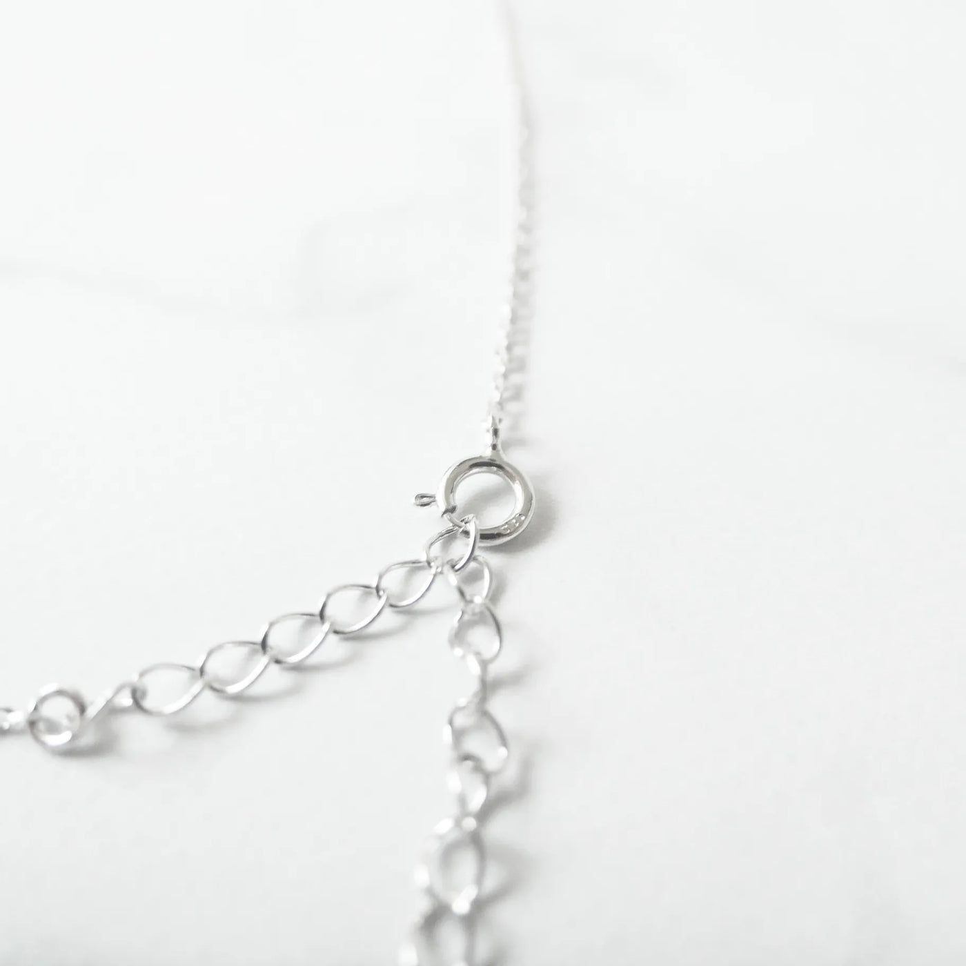 オパールとクリスタルチャームが並んだ、繊細で軽やかなシルバーネックレス。ロジウムプレーティング、金属アレルギー対応。