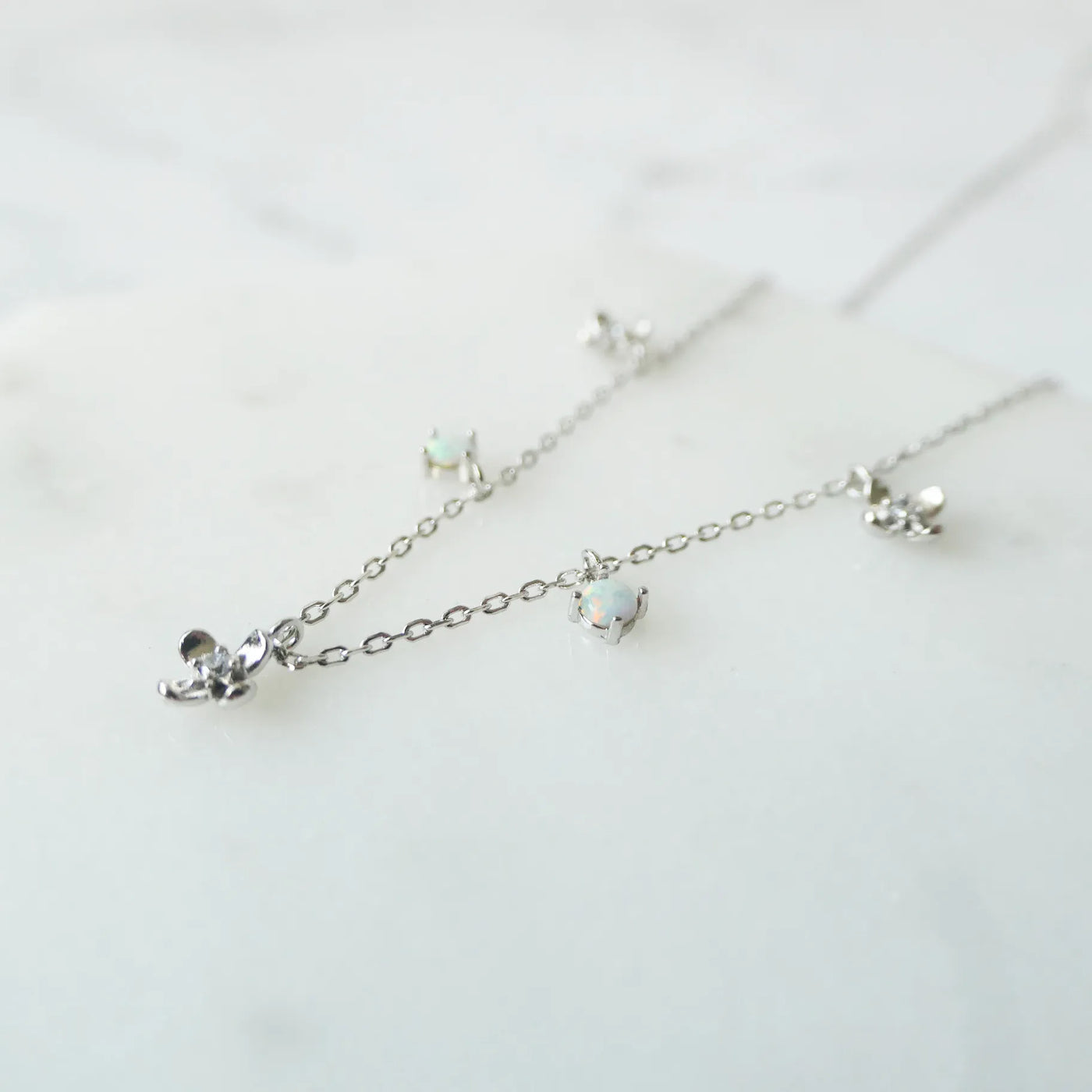 オパールとクリスタルチャームが並んだ、繊細で軽やかなシルバーネックレス。ロジウムプレーティング、金属アレルギー対応。