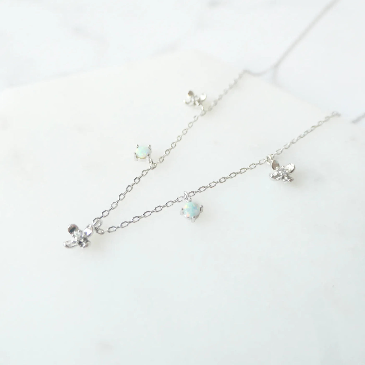 オパールとクリスタルチャームが並んだ、繊細で軽やかなシルバーネックレス。ロジウムプレーティング、金属アレルギー対応。