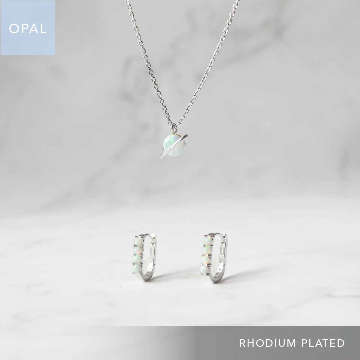 オパールを使用した惑星モチーフネックレスとハギーピアスの2点セット（シルバー925／ロジウムプレーティング）。虹色の輝きと金属アレルギー対応仕様。
Opal planet motif necklace and huggie earrings set in 925 sterling silver, rhodium plated with iridescent glow and hypoallergenic design.