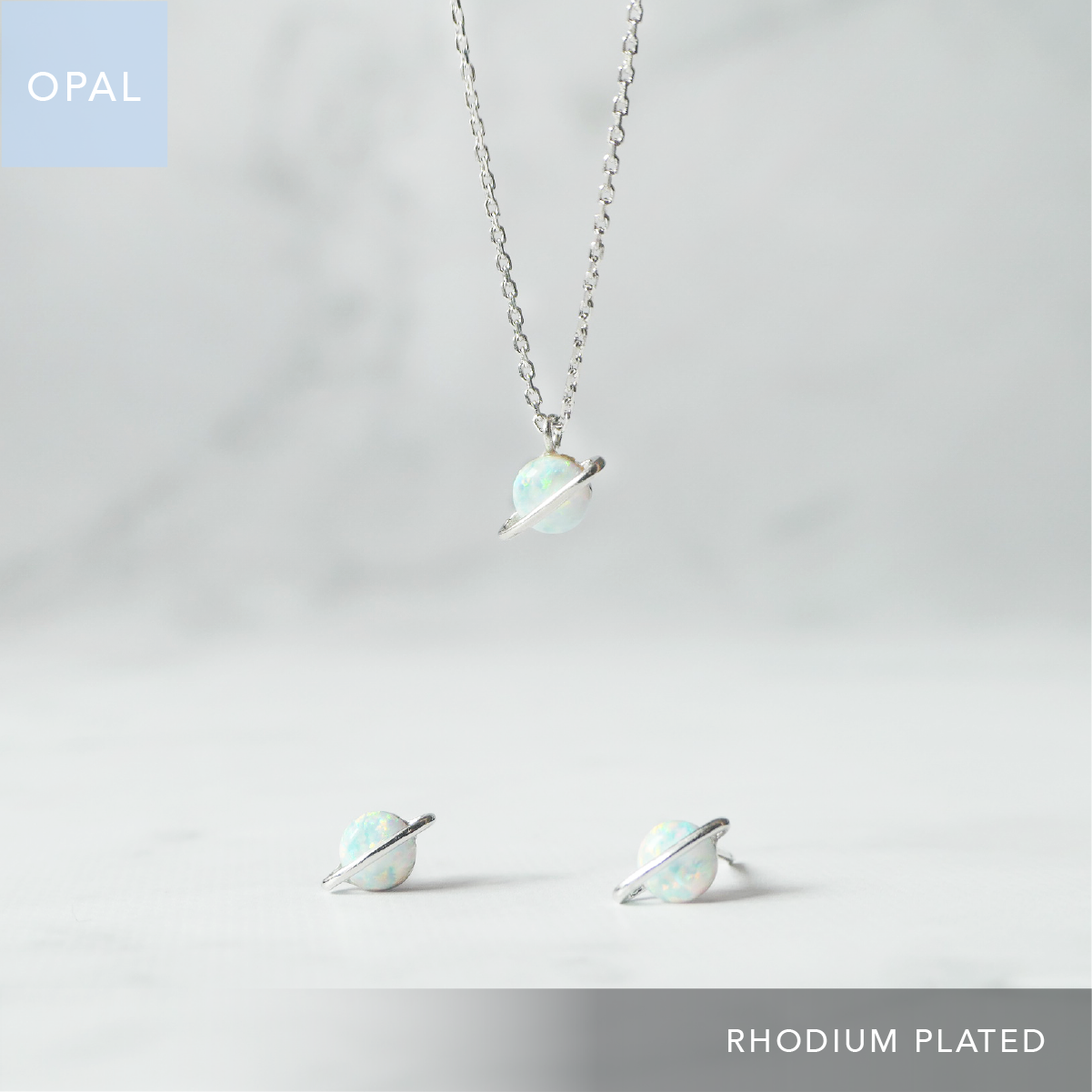 オパールの惑星モチーフネックレスとピアスの2点セット（シルバー925／ロジウムプレーティング）。虹色に輝く天然石と金属アレルギー対応仕様。Opal planet motif necklace and earrings set in 925 sterling silver, rhodium plated with iridescent play-of-color and hypoallergenic design.