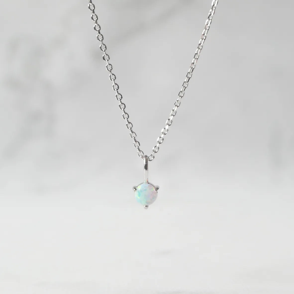 一粒オパールが虹色の遊色を放つシルバー925ロジウムプレーティングラウンドネックレス。シンプルで重ね着けにも最適／金属アレルギー対応。