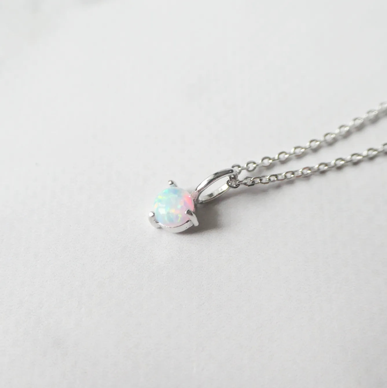 一粒オパールが虹色の遊色を放つシルバー925ロジウムプレーティングラウンドネックレス。シンプルで重ね着けにも最適／金属アレルギー対応。