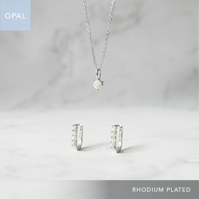 オパールのネックレスとハギーピアス2点セット（シルバー925／ロジウムプレーティング）。虹色の遊色が美しく金属アレルギー対応。Opal necklace and huggie earrings set in 925 sterling silver, rhodium plated with iridescent play-of-color and hypoallergenic finish.