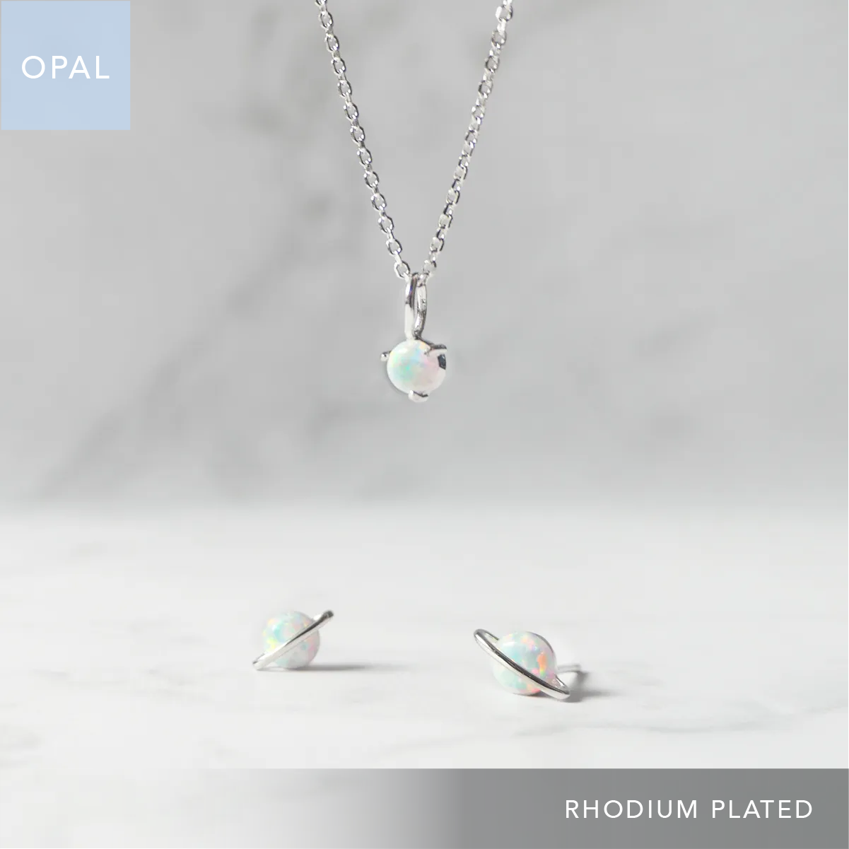 オパールのソリティアネックレスとプラネットモチーフ ピアスの2点セット。シルバー925／ロジウムプレーティング、虹色の遊色が魅力。金属アレルギー対応。Opal solitaire necklace and planet-motif stud earrings set. 925 sterling silver, rhodium plated with iridescent play-of-color. Hypoallergenic.