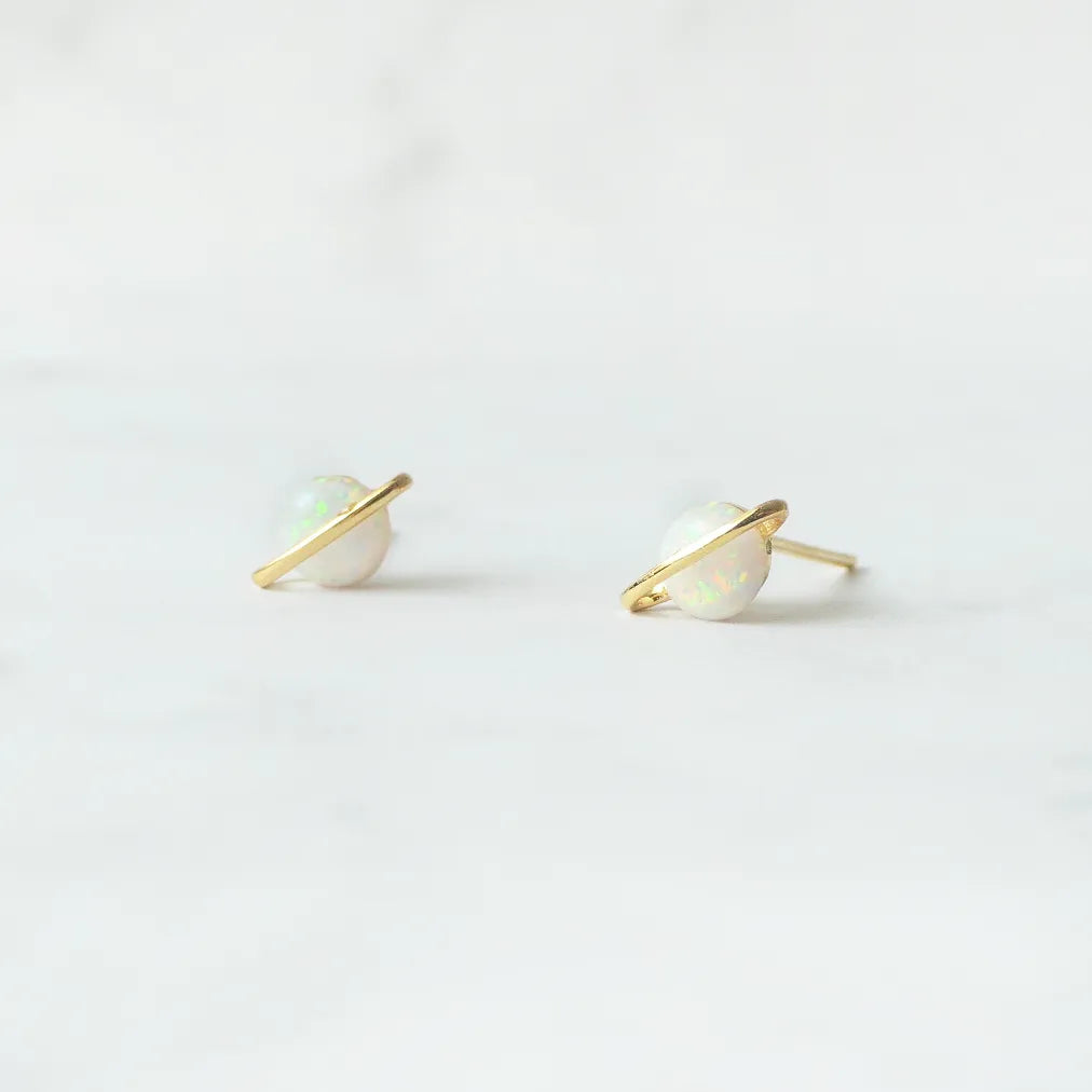 虹色の遊色を放つ天然オパールを18Kゴールドカラーのフレームに包み込んだ、惑星のように幻想的なスタッドピアス。シルバー925に18Kゴールドプレーティングを施し、耳元を柔らかく華やかに彩るデザイン。金属アレルギー対応。