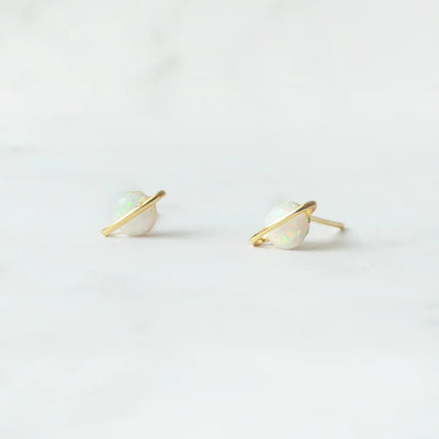 虹色の遊色を放つ天然オパールを18Kゴールドカラーのフレームに包み込んだ、惑星のように幻想的なスタッドピアス。シルバー925に18Kゴールドプレーティングを施し、耳元を柔らかく華やかに彩るデザイン。金属アレルギー対応。
