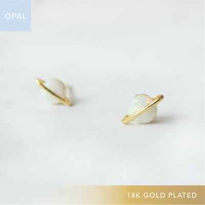 虹色の遊色を放つ天然オパールを18Kゴールドカラーのフレームに包み込んだ、惑星のように幻想的なスタッドピアス。シルバー925に18Kゴールドプレーティングを施し、耳元を柔らかく華やかに彩るデザイン。金属アレルギー対応。