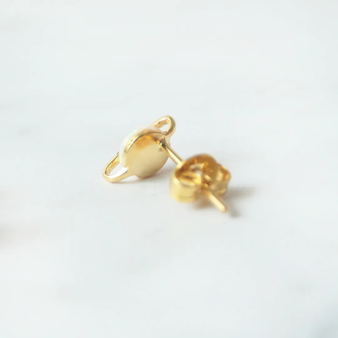 虹色の遊色を放つ天然オパールを18Kゴールドカラーのフレームに包み込んだ、惑星のように幻想的なスタッドピアス。シルバー925に18Kゴールドプレーティングを施し、耳元を柔らかく華やかに彩るデザイン。金属アレルギー対応。