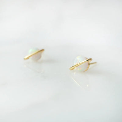 虹色の遊色を放つ天然オパールを18Kゴールドカラーのフレームに包み込んだ、惑星のように幻想的なスタッドピアス。シルバー925に18Kゴールドプレーティングを施し、耳元を柔らかく華やかに彩るデザイン。金属アレルギー対応。