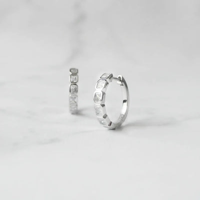 スクエアカットのジルコニアを並べたシルバー925ロジウムプレーティングフープピアス。モダンで上品な輝き、金属アレルギー対応。
Hoop earrings with square-cut zirconia in 925 sterling silver, rhodium plated. Modern, elegant sparkle, hypoallergenic.