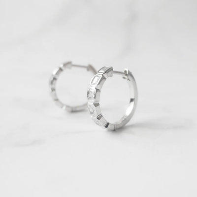 スクエアカットのジルコニアを並べたシルバー925ロジウムプレーティングフープピアス。モダンで上品な輝き、金属アレルギー対応。
Hoop earrings with square-cut zirconia in 925 sterling silver, rhodium plated. Modern, elegant sparkle, hypoallergenic.