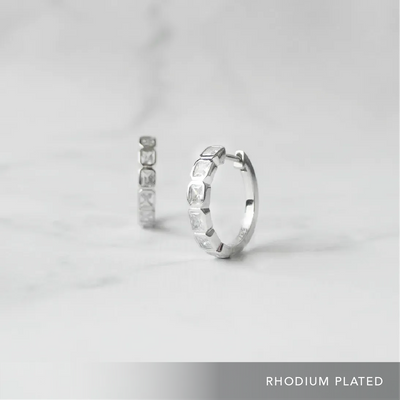 スクエアカットのジルコニアを並べたシルバー925ロジウムプレーティングフープピアス。モダンで上品な輝き、金属アレルギー対応。
Hoop earrings with square-cut zirconia in 925 sterling silver, rhodium plated. Modern, elegant sparkle, hypoallergenic.