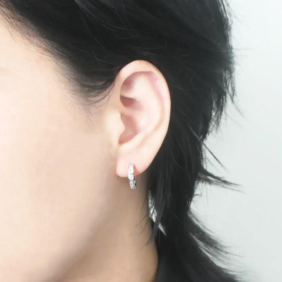 スクエアカットのジルコニアを並べたシルバー925ロジウムプレーティングフープピアス。モダンで上品な輝き、金属アレルギー対応。
Hoop earrings with square-cut zirconia in 925 sterling silver, rhodium plated. Modern, elegant sparkle, hypoallergenic.