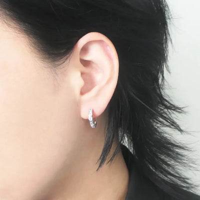 スクエアカットのジルコニアを並べたシルバー925ロジウムプレーティングフープピアス。モダンで上品な輝き、金属アレルギー対応。
Hoop earrings with square-cut zirconia in 925 sterling silver, rhodium plated. Modern, elegant sparkle, hypoallergenic.