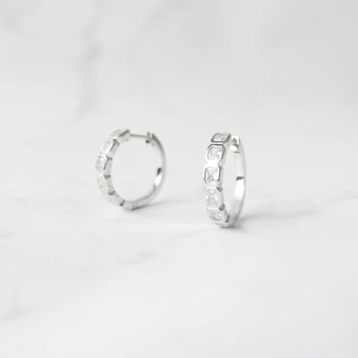 スクエアカットのジルコニアを並べたシルバー925ロジウムプレーティングフープピアス。モダンで上品な輝き、金属アレルギー対応。
Hoop earrings with square-cut zirconia in 925 sterling silver, rhodium plated. Modern, elegant sparkle, hypoallergenic.