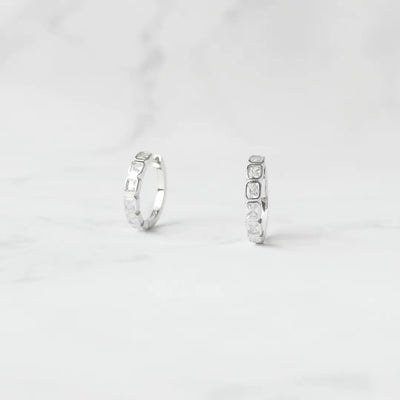 スクエアカットのジルコニアを並べたシルバー925ロジウムプレーティングフープピアス。モダンで上品な輝き、金属アレルギー対応。
Hoop earrings with square-cut zirconia in 925 sterling silver, rhodium plated. Modern, elegant sparkle, hypoallergenic.
