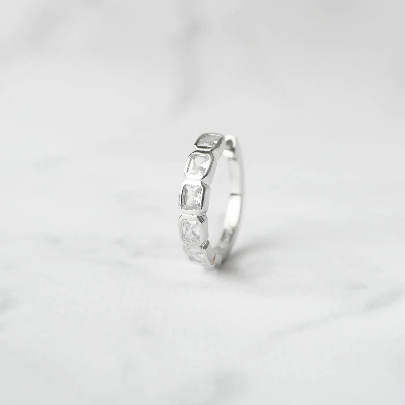 スクエアカットのジルコニアを並べたシルバー925ロジウムプレーティングフープピアス。モダンで上品な輝き、金属アレルギー対応。
Hoop earrings with square-cut zirconia in 925 sterling silver, rhodium plated. Modern, elegant sparkle, hypoallergenic.